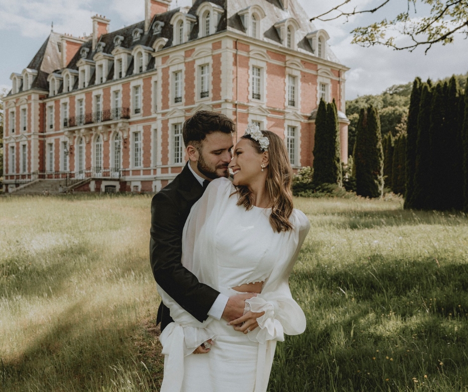 Bride and Groom in an embrace on the lawn of the estate with the Chateau de la Cazine as the backfrop on a sunny day