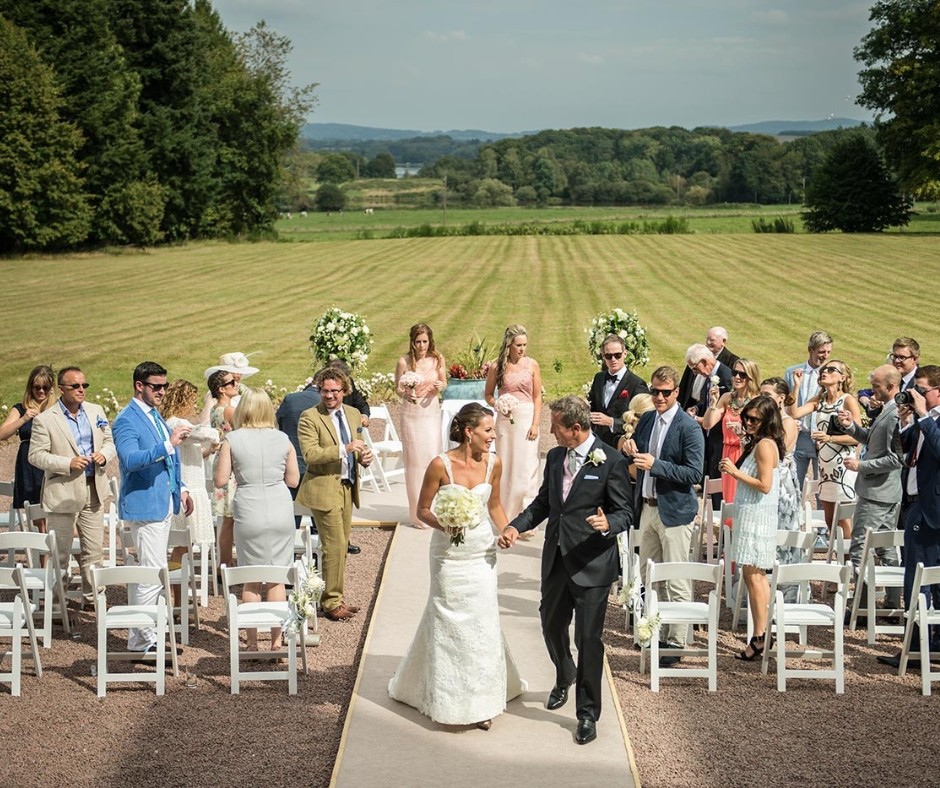 Couple walking down the aise during their outdoor wedding ceremony at chateau de la cazine with their wedding guests