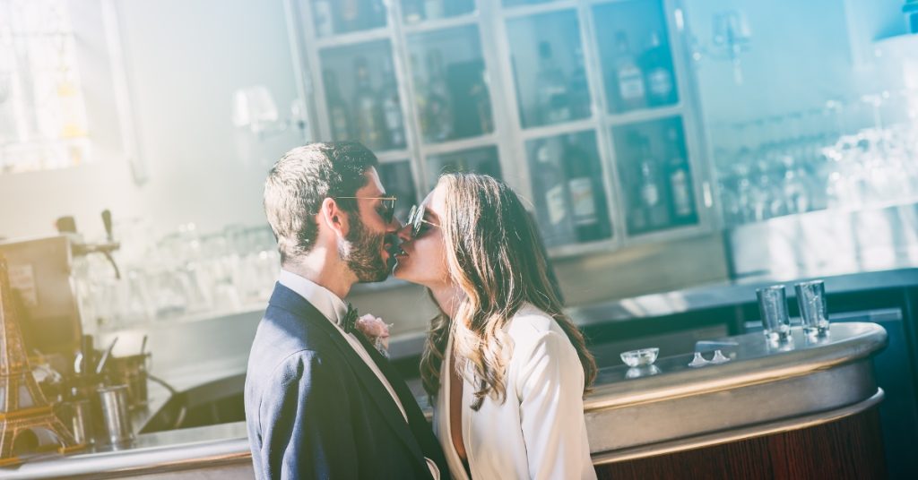 Emilie and Vael Wedding day at Chateau de la Cazine, kissing at the bar