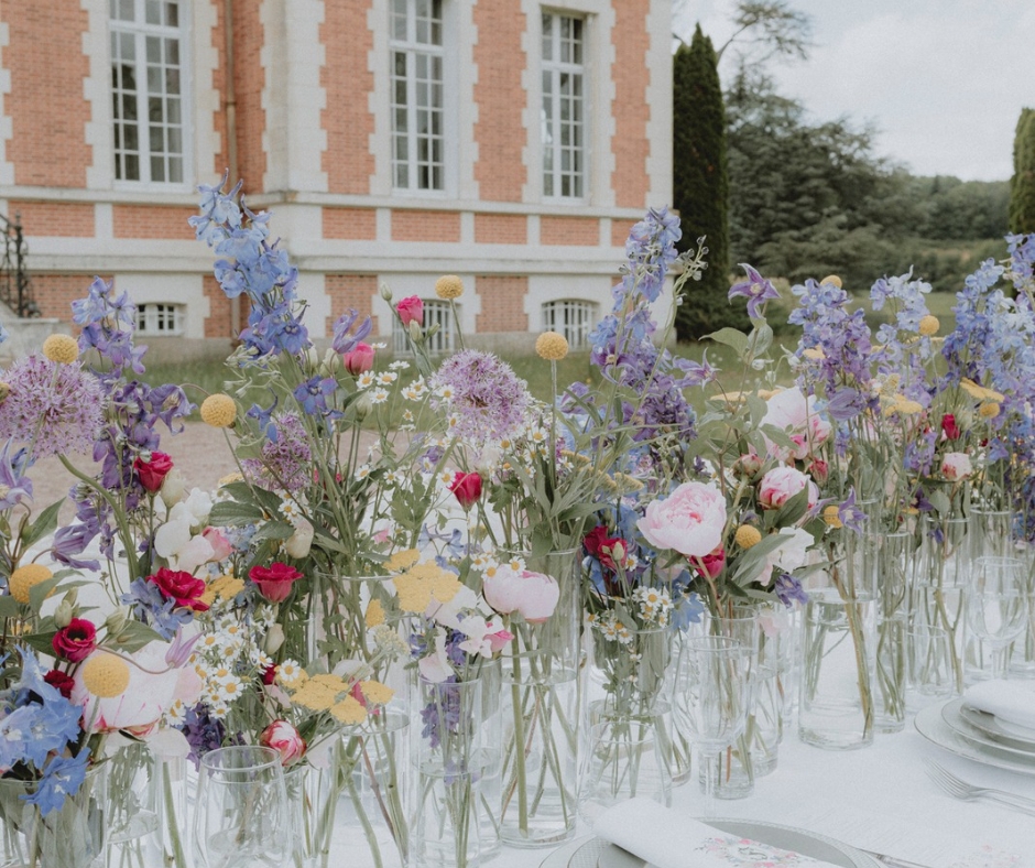 Pretty colourful flowers as centriepieces of the tablescape on the terrace of Chateau de la Cazine. Dainty vases with Peonies, daisies and violets. 