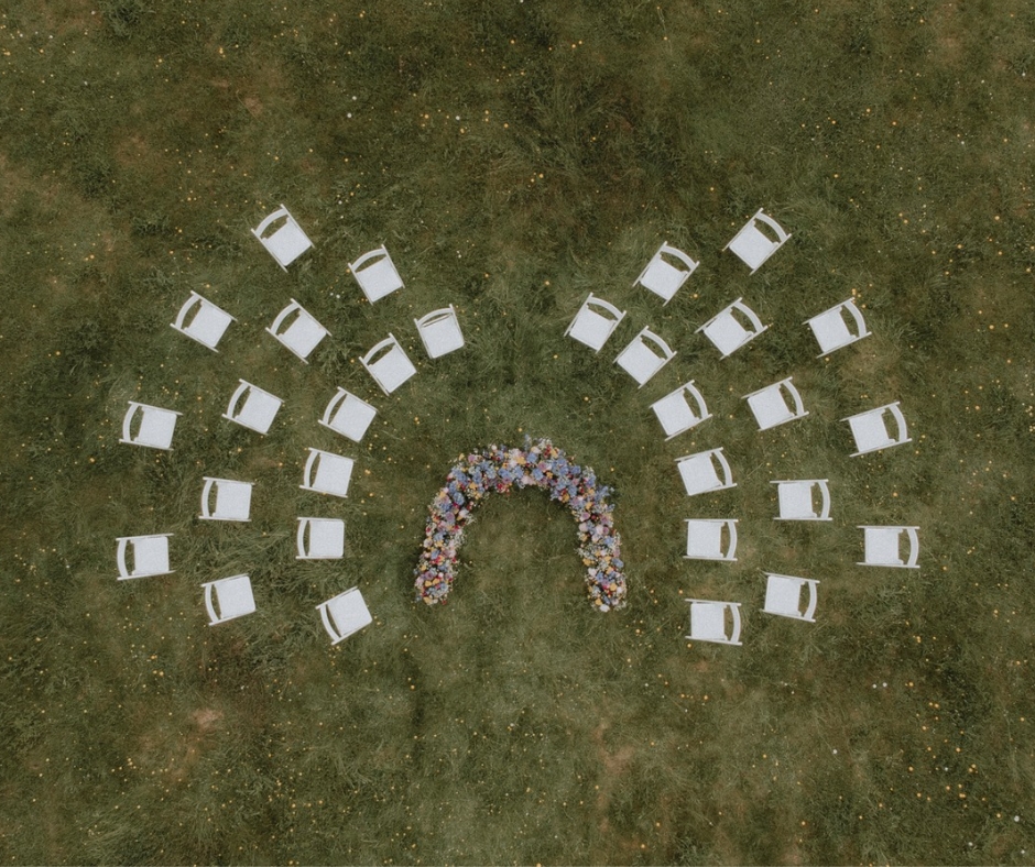 Outdoor ceremony Space set up on the lawn of chateau de la Cazine. Folding White chairs placed in a circular formation with the floral arrangement in the middle for the bride and groom to stand in.